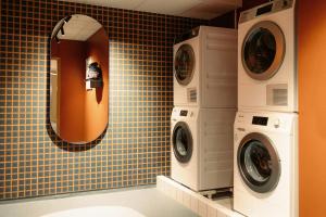a bathroom with two washing machines and a mirror at Scandic Go, Saaristonkatu 1 in Oulu
