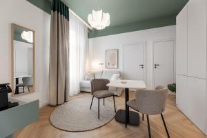 a living room with a table and chairs at Catalog Boutique Rooms Debrecen in Debrecen