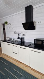 a white kitchen with a sink and a microwave at Scandidim Lutsk in Lutsk