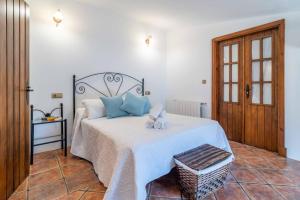a bedroom with a bed with blue pillows on it at El Acebuchal de Ubrique in Ubrique