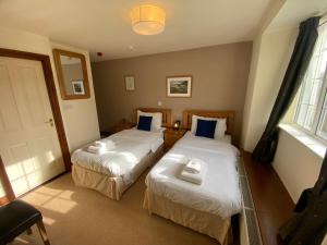 two beds in a hotel room with a window at The Globe Inn in Kingsbridge +17 photos