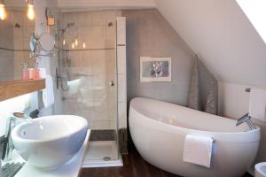 a bathroom with a large white tub and a sink at Drahthammer Schlößl in Amberg