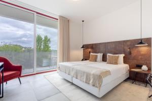 a bedroom with a bed and a large window at Hotel da Barrosinha in Alcácer do Sal