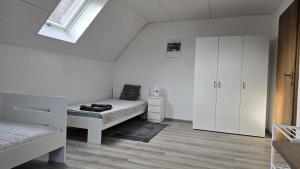 a white room with a bed and a cabinet at Room4U in Memmingen