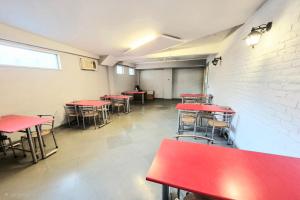 an empty room with red tables and chairs at Premium Nest, Golf Course Road in Gurgaon