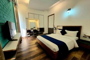 a bedroom with a bed and a flat screen tv at Premium Nest, Golf Course Road in Gurgaon