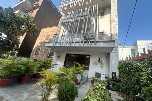 a building with a balcony and plants in front of it at Premium Nest, Golf Course Road in Gurgaon