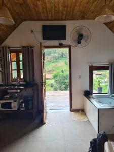 a kitchen with a sink and a door with a window at Chalé 2 com hidromassagem in Camanducaia
