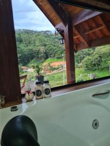 a room with a window with a view of a field at Chalé 2 com hidromassagem in Camanducaia +6 photos