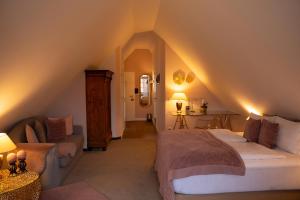 a attic bedroom with a bed and a couch at Drahthammer Schlößl in Amberg