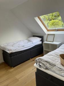 two beds in a small room with a window at Ferienwohnung Benz in Löningen