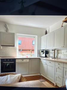 a kitchen with white cabinets and a window at Ferienwohnung Benz in Löningen