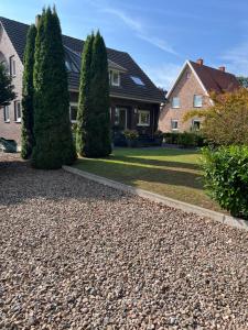 a house with two trees in front of a driveway at Ferienwohnung Benz in Löningen