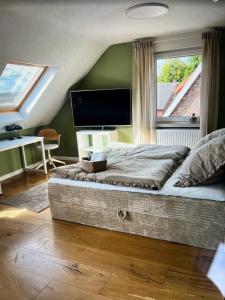 a bedroom with a bed with a tv and a window at Ferienwohnung Benz in Löningen +6 photos
