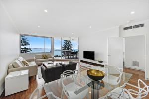 a living room with a couch and a table at Sandcastle Apartments in Port Macquarie
