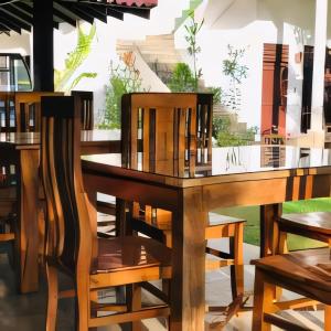 a wooden table and chairs at a restaurant at Green Haven Yala Safari Retreat in Tissamaharama