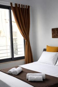 a bedroom with a bed with two towels on it at Twin Apartment in St. Julianʼs