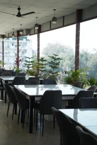 a restaurant with tables and chairs and a large window at Hotel Bindram Palace - Rishikesh in Rishīkesh