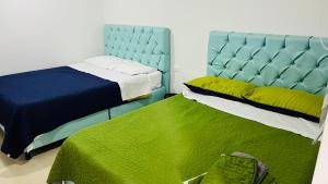 a bedroom with two beds and a blue headboard at HOTEL DEL MINERO Otanche in Otanche +33 photos