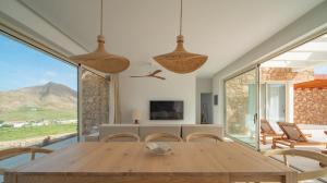 a dining room with a wooden table and chairs at Villa Gypsy by Aura Collection in Tindaya +22 photos