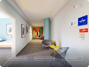 a hallway with a bed and a table and chairs at Bello ApartHostel Private Rooms in Warsaw