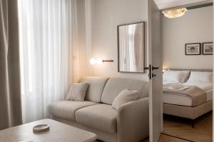 a living room with a couch and a bed at Catalog Boutique Rooms Debrecen in Debrecen