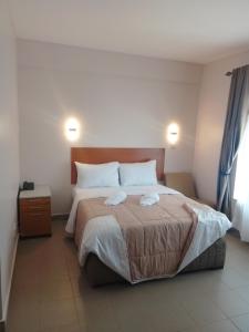 ein Schlafzimmer mit einem Bett, auf dem zwei Handtücher liegen in der Unterkunft Atlas Hotel in Arusha