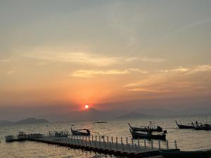 a group of boats on the water at sunset at Phayamhostel in Ko Phayam +13 photos