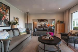 a living room with a couch and a table at Fransmanskraal Accommodation - Luxury Stellenbosch Farm Villa in Stellenbosch