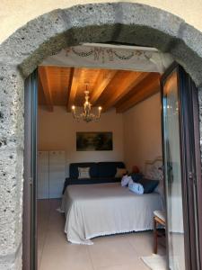 a bedroom with a bed and a stone wall at Riccioli dell' Etna in Piedimonte Etneo