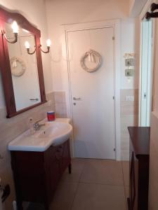 a bathroom with a sink and a white door at Riccioli dell' Etna in Piedimonte Etneo +30 photos