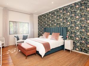 a bedroom with a large bed with a floral wallpaper at Fransmanskraal Accommodation - Luxury Stellenbosch Farm Villa in Stellenbosch