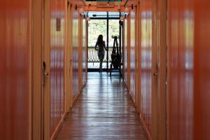 a woman walking down a hallway with wooden floors at Klika Bocas del Toro in Bocas Town