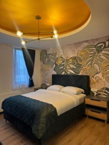 a bedroom with a large bed with a yellow ceiling at Pansion Afitos in Laktaši
