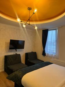 a bedroom with a bed and a couch and a tv at Pansion Afitos in Laktaši