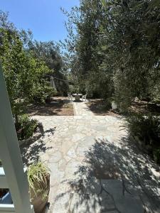a stone walkway with trees and plants on it at Our Summer Nest in Panormos Skopelos +2 photos