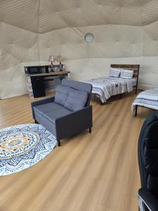 a living room with two beds and a chair at Baddeck Domes in Baddeck