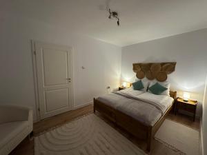 a bedroom with a bed with a large wooden headboard at Central House - Modern Apartment in Zărneşti