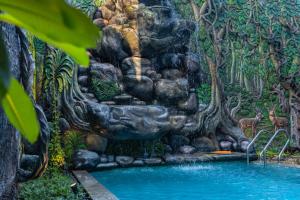 a fountain in front of a waterfall in a forest at Amera Hiriketiya in Dickwella