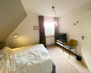 a bedroom with a bed and a desk and a television at AHOI MARIE in Blekendorf