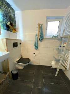 a bathroom with a black toilet and a window at AHOI MARIE in Blekendorf