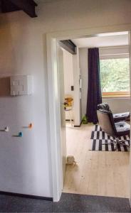 an open door to a living room with a chair at AHOI MARIE in Blekendorf +22 photos