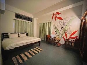 a bedroom with a bed and a flower mural on the wall at White Lotus in North Lakhimpur