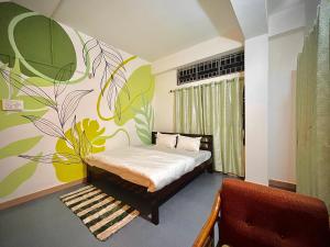 a bedroom with a bed with a flower mural on the wall at White Lotus in North Lakhimpur