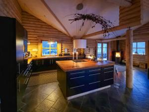 a large kitchen with a large island in a room at Round Timber House In Forest Near Mariager in Hadsund
