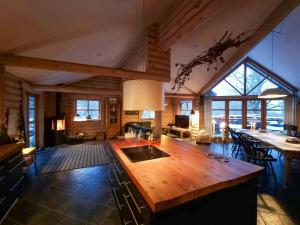 a large kitchen with a large wooden island in a room at Round Timber House In Forest Near Mariager in Hadsund