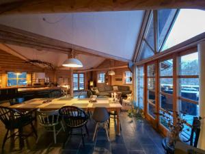a dining room with a table and chairs at Round Timber House In Forest Near Mariager in Hadsund