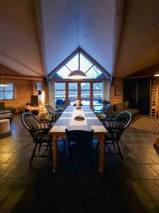 a large dining room with a table and chairs at Round Timber House In Forest Near Mariager in Hadsund +18 photos