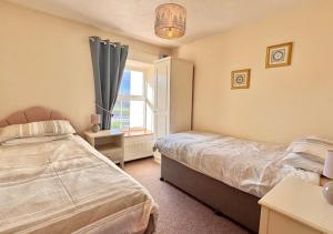 a bedroom with two beds and a window at Seacrest Cottage in Conwy