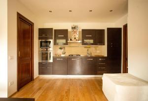a kitchen with brown cabinets and a wooden floor at Relax Pescasseroli For Ever in Pescasseroli